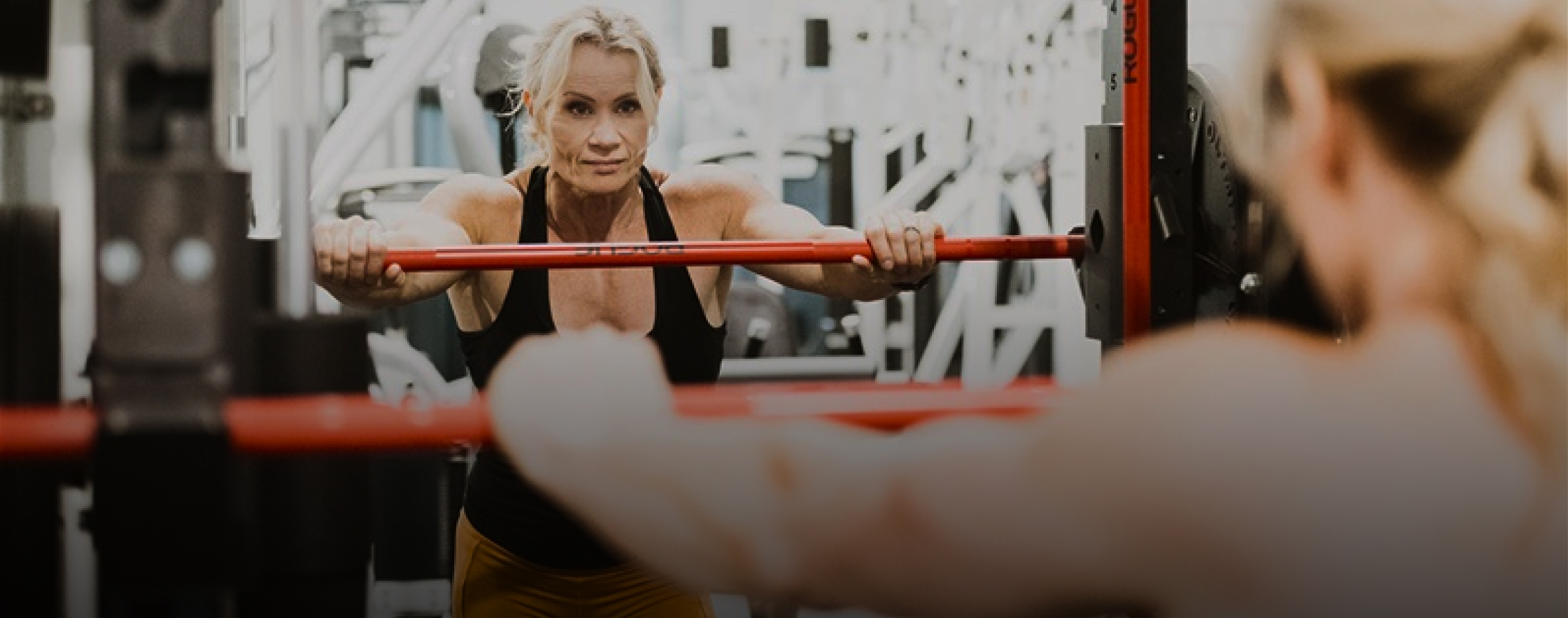 Lisa Giesbrecht coaching a client at the squat rack